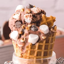 A scoop of Rocky Road ice cream with visible marshmallows and nuts