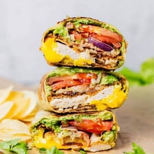 A tortilla wrap filled with vegetables and sliced chicken.