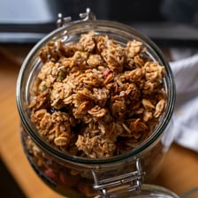 Oat grains beside a bowl of granola