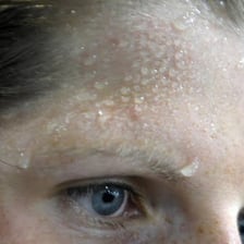 Small beads of sweat visible on a person’s forehead.