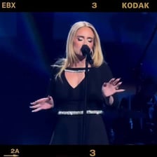 Adele singing during a live performance.