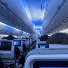 An airplane cabin viewed along its central aisle.