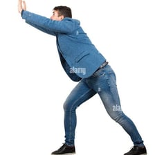 A person forcefully pushing a large object