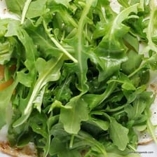 Fresh arugula leaves shown as a salad green.
