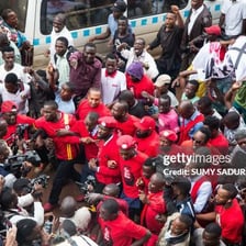 A large, disorderly crowd gathered in a public place.