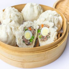 Steamed pork buns, or bao, arranged in a bamboo steamer.