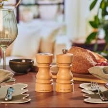 A salt shaker with a perforated lid on a dining table