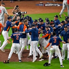Houston Astros players in team uniforms on a baseball field.