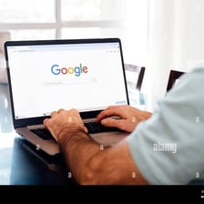 A person using a laptop to search for information online.