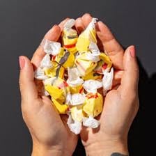 A person chewing a piece of taffy.