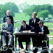 A photograph depicts the 1990 signing of the Americans with Disabilities Act.