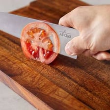 A chef cutting vegetables into small cubes.