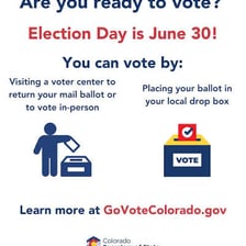 A voter placing a completed ballot into a ballot box.