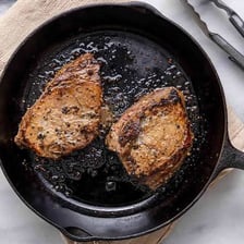 A steak browning in a hot skillet
