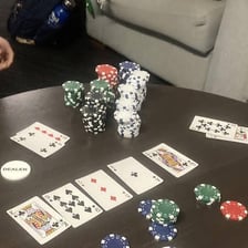 Playing cards arranged as a royal flush on a poker table.