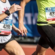 A runner wearing a numbered race bib on the front of a shirt