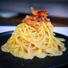 A plate of pasta alla carbonara with sauce and cheese