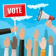 A group of people participating in an informal show-of-hands poll.