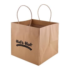 A restaurant takeout bag containing packaged food