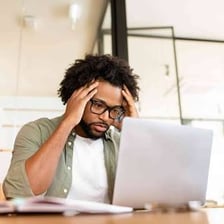 A person sitting with visibly tense, anxious body language