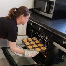 A tray of cupcakes baking in an oven