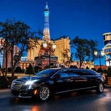 A stretch limousine waiting outside a hotel.
