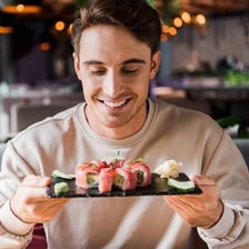 A person eating sushi with chopsticks