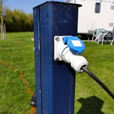 A recreational vehicle connected to campground utility hookups