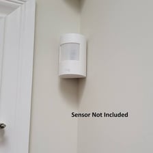 A motion detector mounted on an interior wall.
