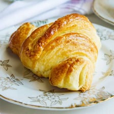 A small croissant sits on a plate.