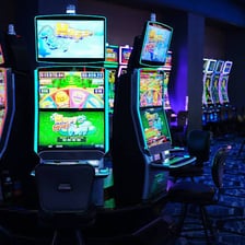 A row of illuminated slot machines in a casino