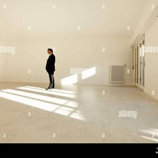 Two people sitting together in an otherwise empty room.