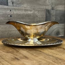 A small serving gravy boat filled with gravy.