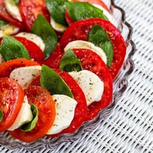 A Caprese salad with basil leaves, tomato, and mozzarella
