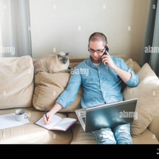 A person working on a laptop from a sofa