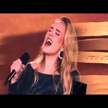 Adele performing onstage.