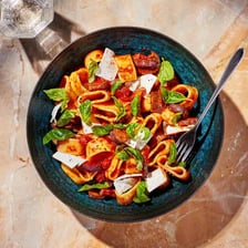 A plate of pasta alla Norma with tomato sauce and eggplant.