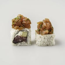A sliced sushi roll with rice visible around its filling.