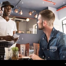 A server writing down a customer's food order at a restaurant.