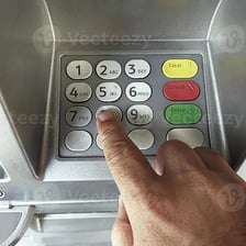 A person entering a personal identification number on an ATM keypad.