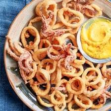 A plate of fried calamari rings served as an appetizer.