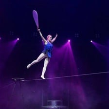 A performer balancing while walking on a tightrope.