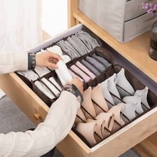 Bras folded among clothing in a drawer.