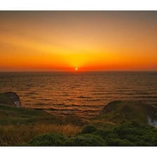 Light appearing over the horizon at sunrise