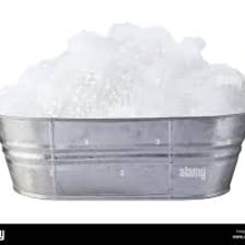 A bathtub covered with white soapy bubbles.