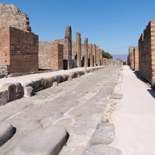 Ancient ruins at the Pompeii archaeological site with Mount Vesuvius nearby