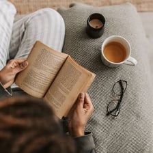 A person enjoying quiet time alone with a book and coffee