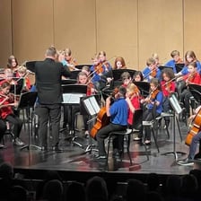 An orchestra performing for the Des Moines Symphony.