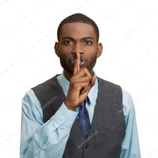 A person holding one finger to their lips in a shushing gesture