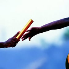 Runners passing a baton during a relay race